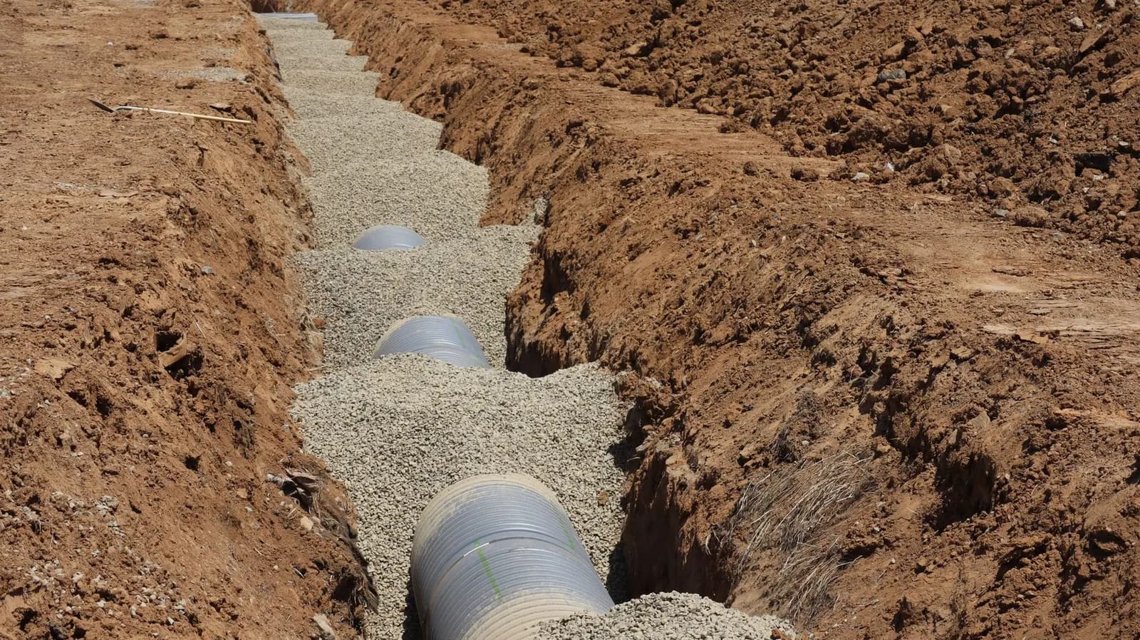 New drainage pipe laid in a gravel-bedded trench
